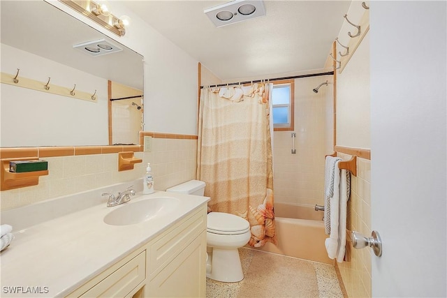 full bathroom with vanity, toilet, tile walls, and shower / tub combo with curtain