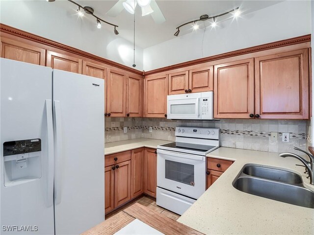 kitchen with decorative backsplash, ceiling fan, white appliances, and sink