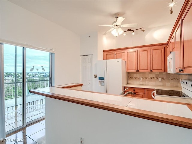 kitchen featuring white appliances, tasteful backsplash, light tile patterned floors, and light countertops