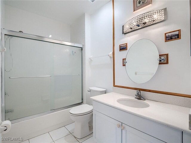 full bathroom featuring tile patterned floors, vanity, toilet, and bath / shower combo with glass door