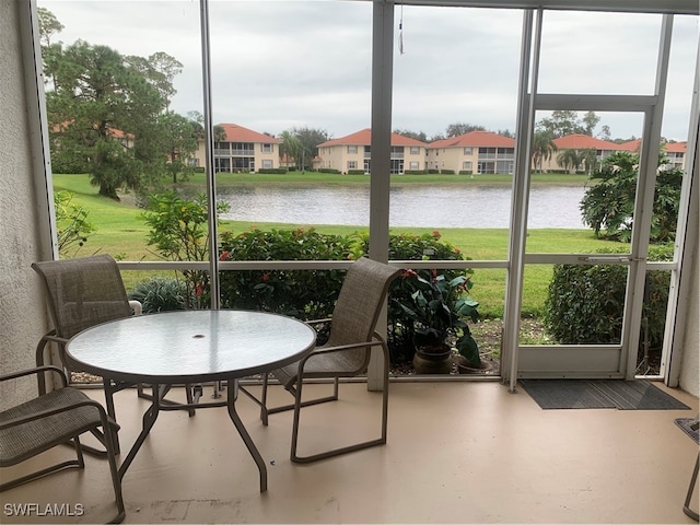 sunroom / solarium featuring a water view