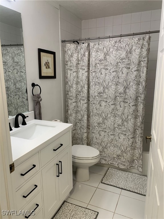 full bathroom with vanity, a textured ceiling, shower / bath combo, tile patterned flooring, and toilet