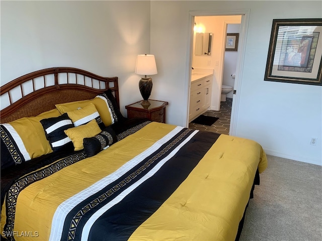 bedroom featuring ensuite bath and carpet flooring