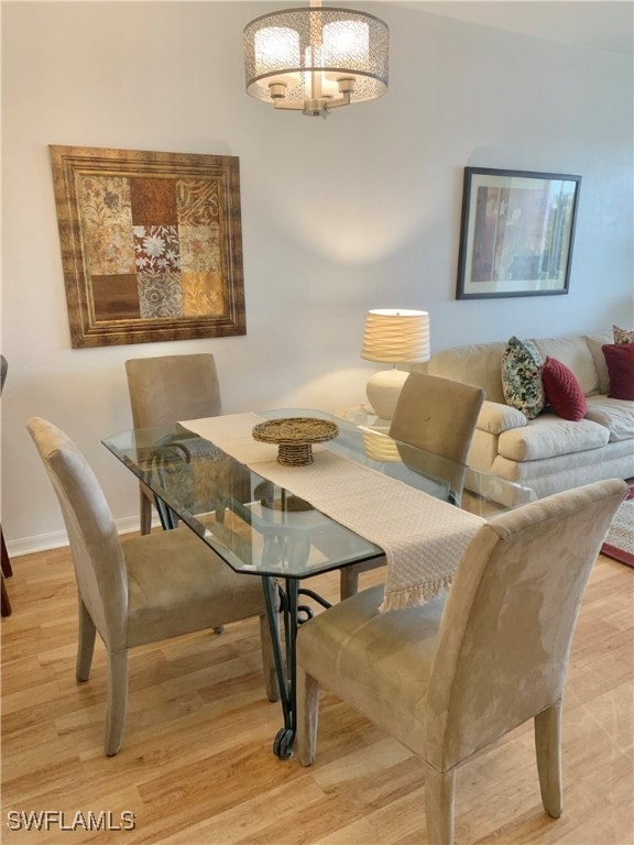 dining area featuring an inviting chandelier and light hardwood / wood-style flooring