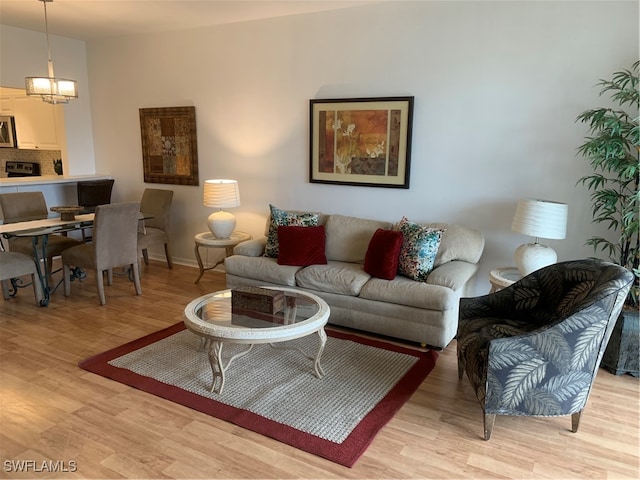 living room with an inviting chandelier and light wood-type flooring