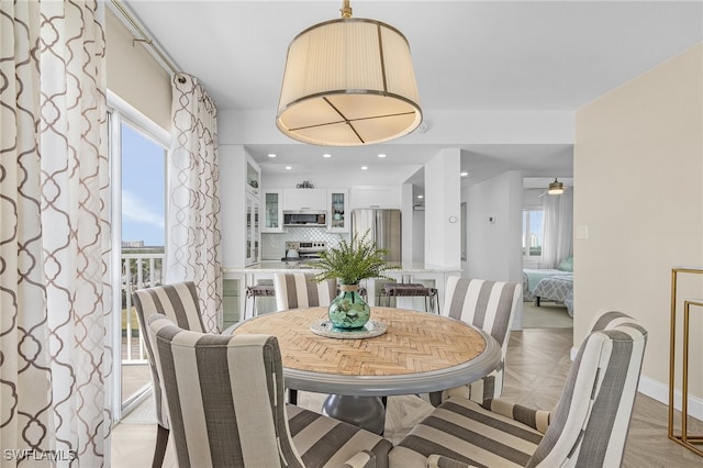 dining area with light parquet floors and ceiling fan