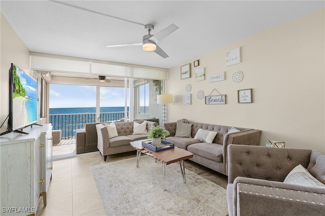 tiled living room with a water view and ceiling fan