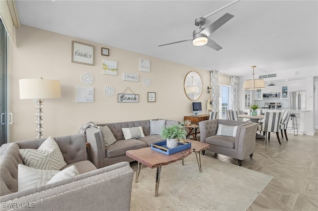 living room featuring light parquet floors and ceiling fan