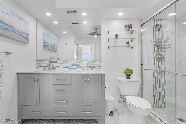 bathroom featuring decorative backsplash, ceiling fan, walk in shower, toilet, and vanity