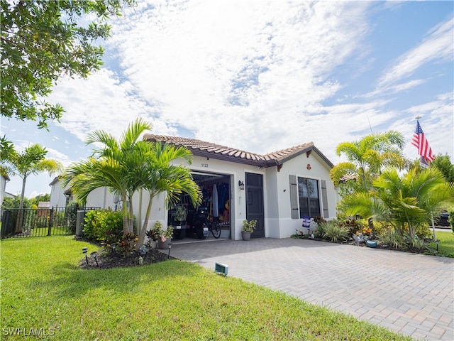 mediterranean / spanish house with a front lawn and a garage