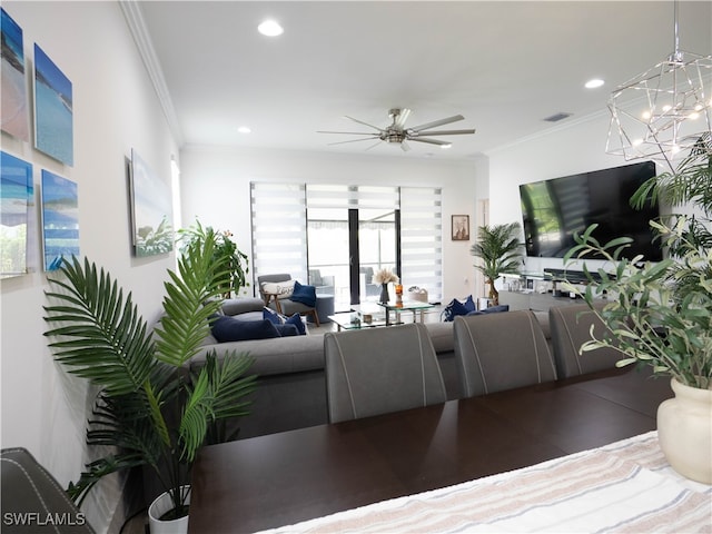 living room featuring ceiling fan with notable chandelier and ornamental molding