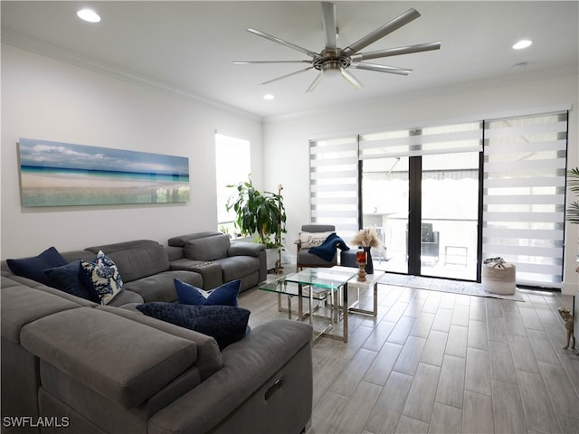 living room with light wood-type flooring, crown molding, and ceiling fan