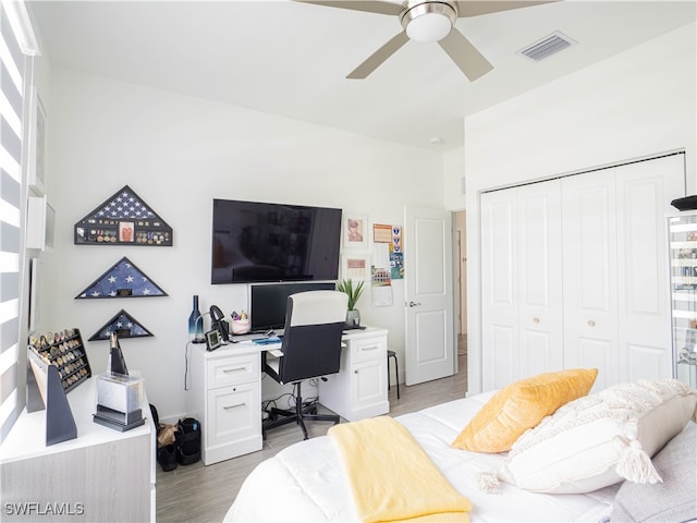 bedroom with light hardwood / wood-style flooring, a closet, and ceiling fan