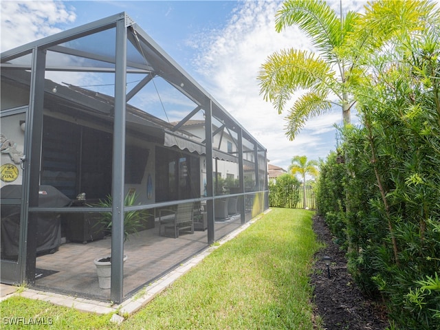 view of home's exterior featuring a lanai, a patio area, and a lawn