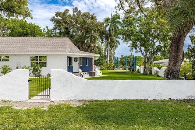 view of front of house with a trampoline and a front yard