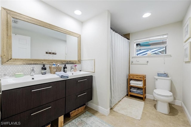 bathroom featuring toilet, vanity, and tasteful backsplash