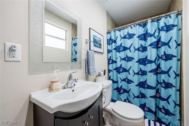 bathroom featuring toilet, vanity, and curtained shower