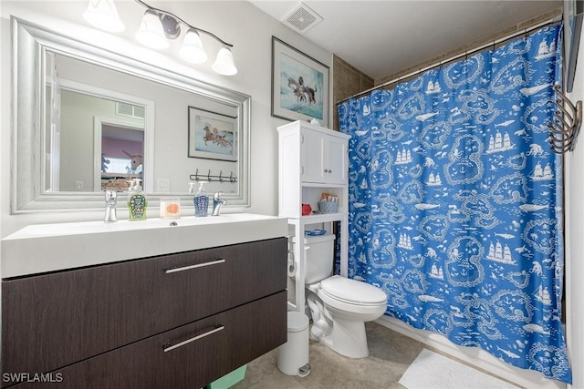 bathroom featuring toilet, vanity, and tile patterned flooring