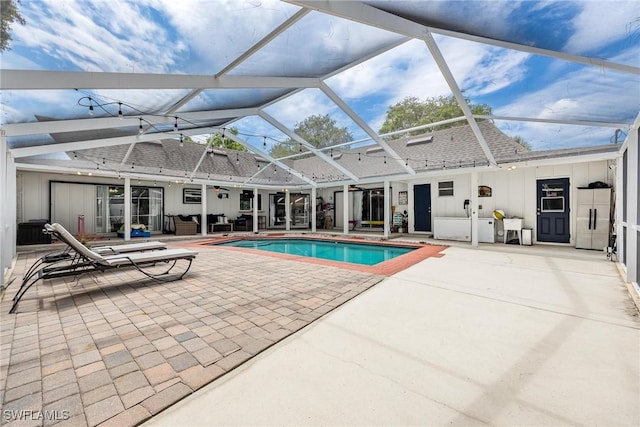 view of swimming pool featuring an outdoor living space, a patio area, and glass enclosure