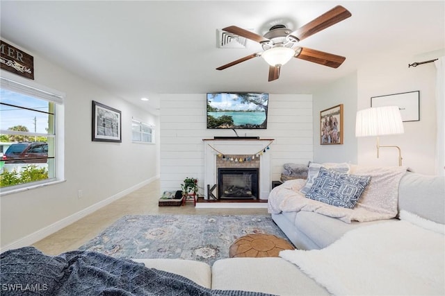 living room with ceiling fan and a fireplace