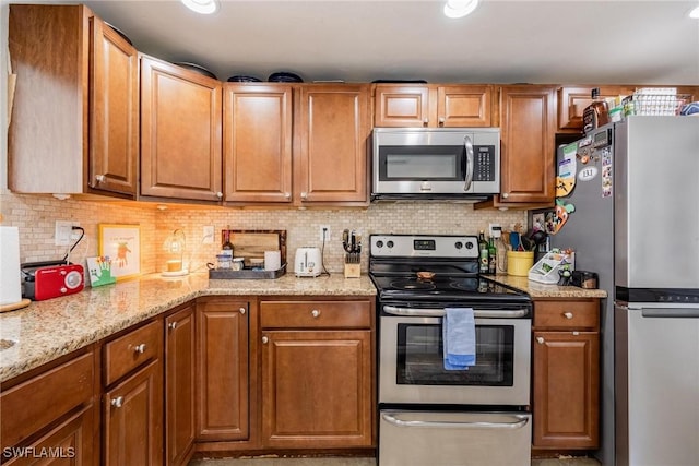 kitchen featuring tasteful backsplash, light stone counters, and stainless steel appliances