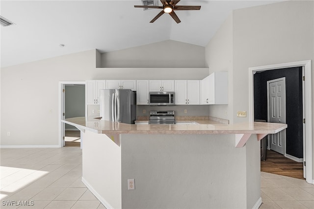 kitchen featuring stainless steel appliances, ceiling fan, light tile patterned flooring, and white cabinetry