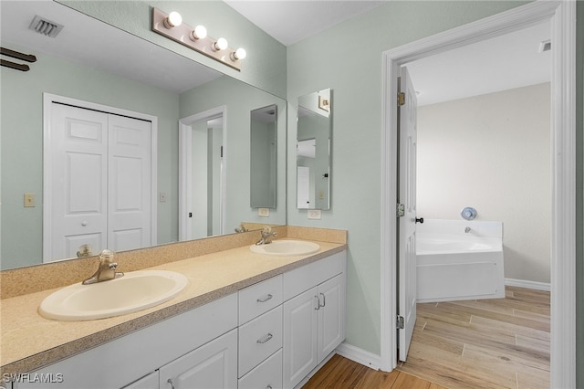 bathroom featuring hardwood / wood-style floors, vanity, and a bathing tub