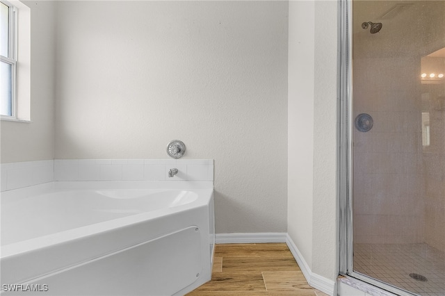 bathroom with wood-type flooring and independent shower and bath