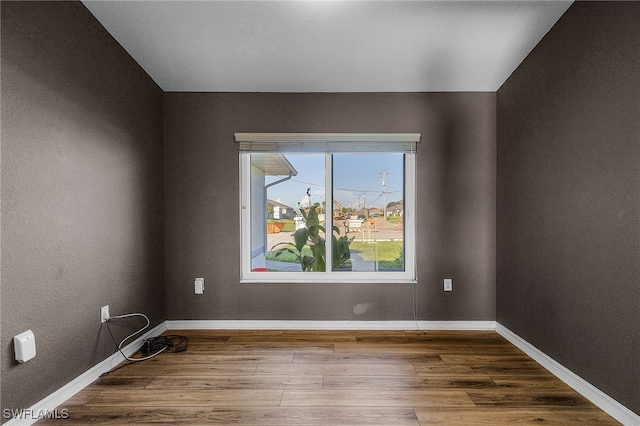 spare room featuring wood-type flooring