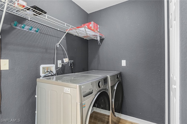 laundry room featuring wood-type flooring and washer and clothes dryer