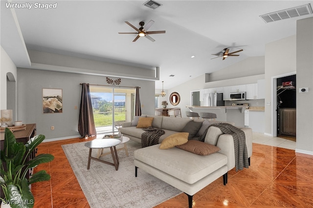 living room featuring vaulted ceiling, light tile patterned floors, and ceiling fan