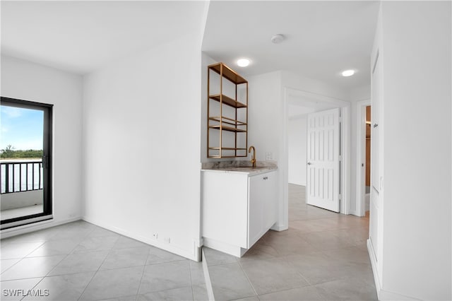 kitchen featuring white cabinetry, sink, and light tile patterned floors