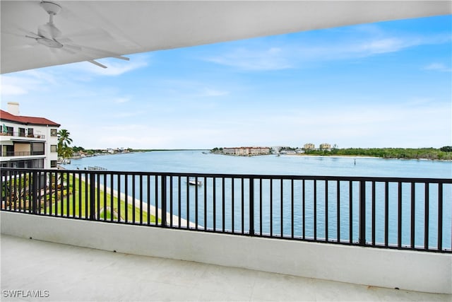 balcony featuring a water view and ceiling fan