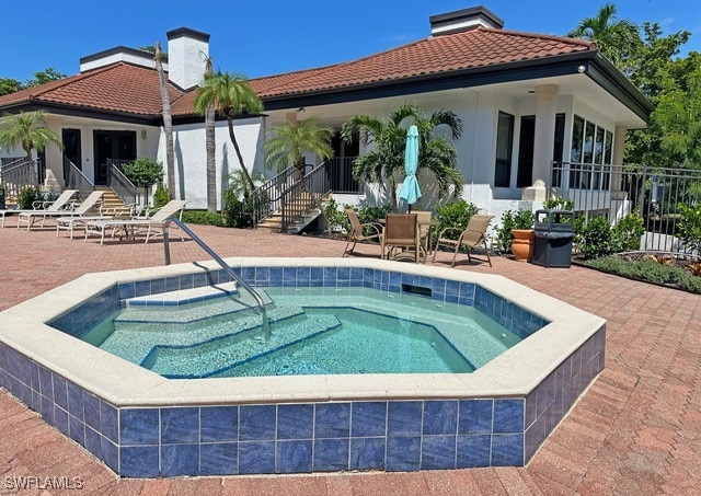 exterior space featuring an in ground hot tub and a patio