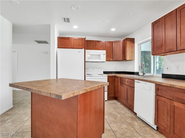 kitchen with light tile patterned flooring, white appliances, a center island, and sink