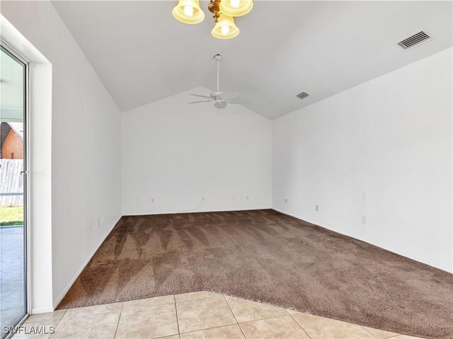 spare room featuring light carpet, vaulted ceiling, and a wealth of natural light