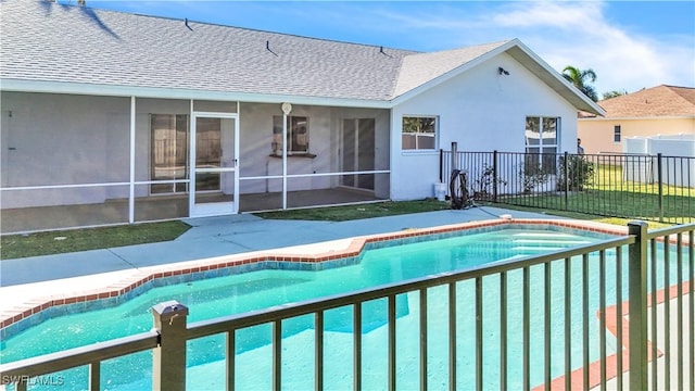 view of swimming pool featuring a lawn and a sunroom