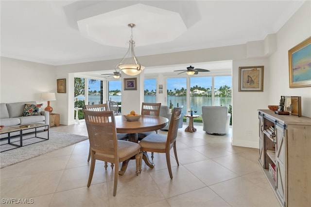 dining area with a water view, ceiling fan, and plenty of natural light