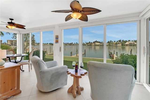 sunroom with a water view and ceiling fan