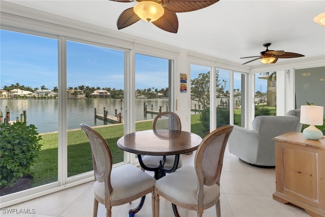 sunroom featuring a water view, ceiling fan, and plenty of natural light