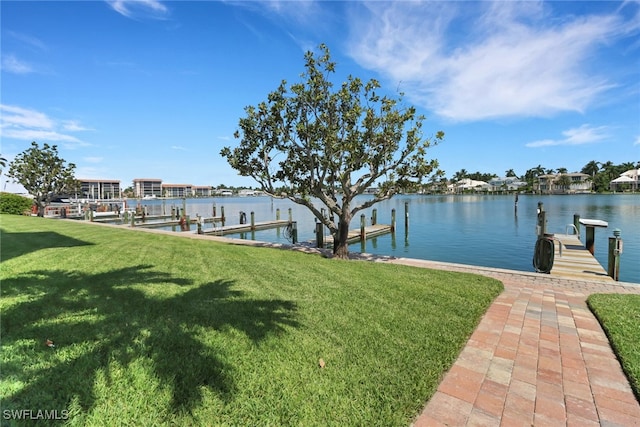 view of dock with a lawn and a water view