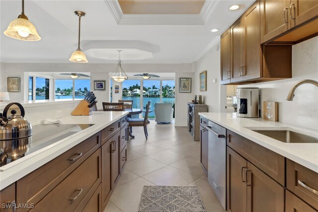 kitchen with hanging light fixtures, a healthy amount of sunlight, a tray ceiling, and ceiling fan