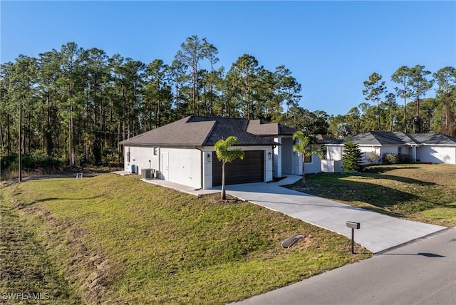 ranch-style home featuring central air condition unit, a front yard, and a garage