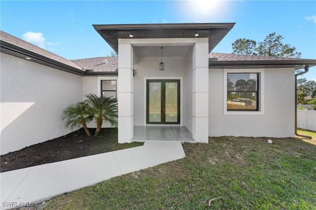 view of exterior entry featuring a lawn