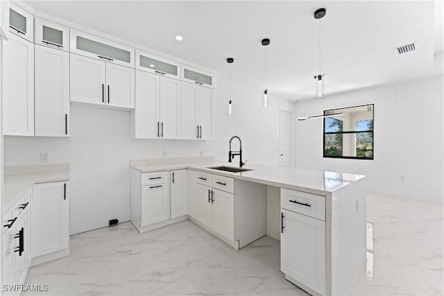 kitchen featuring white cabinetry, sink, a center island, and hanging light fixtures