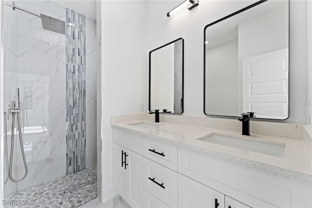 bathroom with a tile shower and vanity