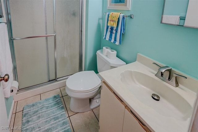 bathroom featuring tile patterned flooring, vanity, toilet, and walk in shower