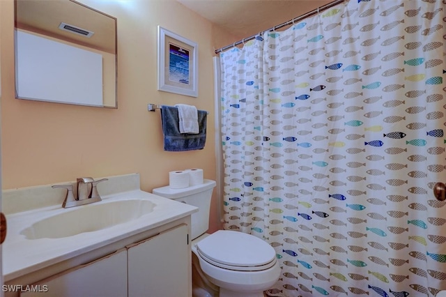 bathroom featuring vanity, a shower with shower curtain, and toilet