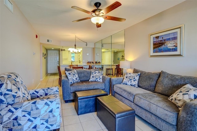 living room with ceiling fan with notable chandelier and light tile patterned floors