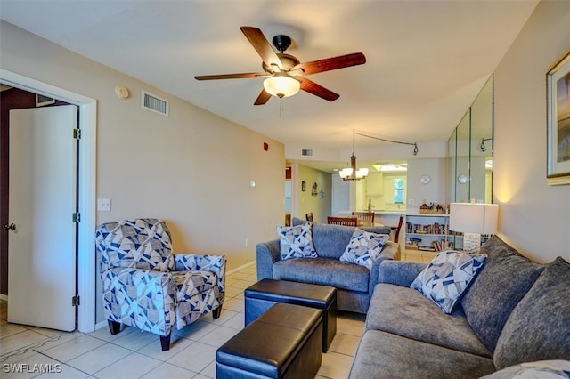 tiled living room featuring ceiling fan with notable chandelier